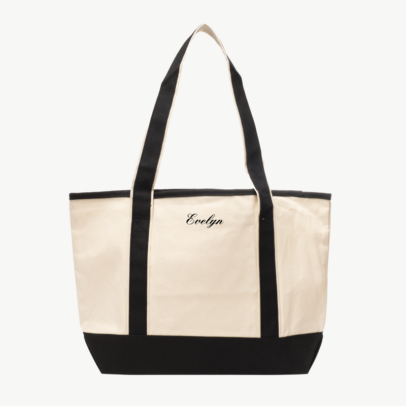 A beige canvas tote bag with long black handles and a matching black base. The name Evelyn is embroidered in black on the front, displayed on a white background.