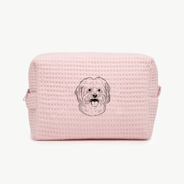 A light pink waffle zippered pouch with a black line drawing of a dogs face on the front.
