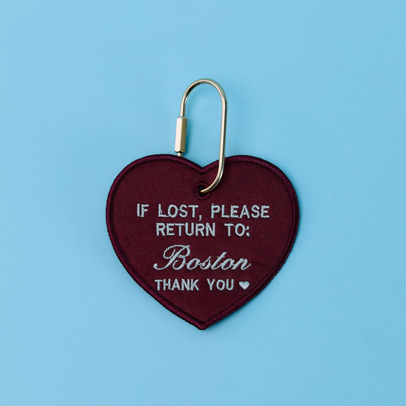 Heart-shaped keychain with text on a blue background