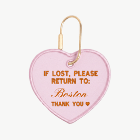 Pink heart-shaped keychain with text on a white background
