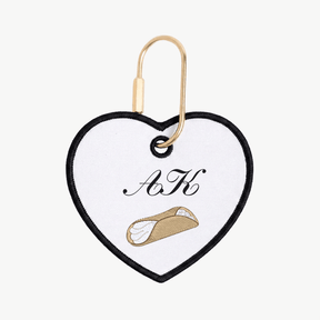Heart-shaped keychain with initials 'A' and 'K' and a small illustration on a white background