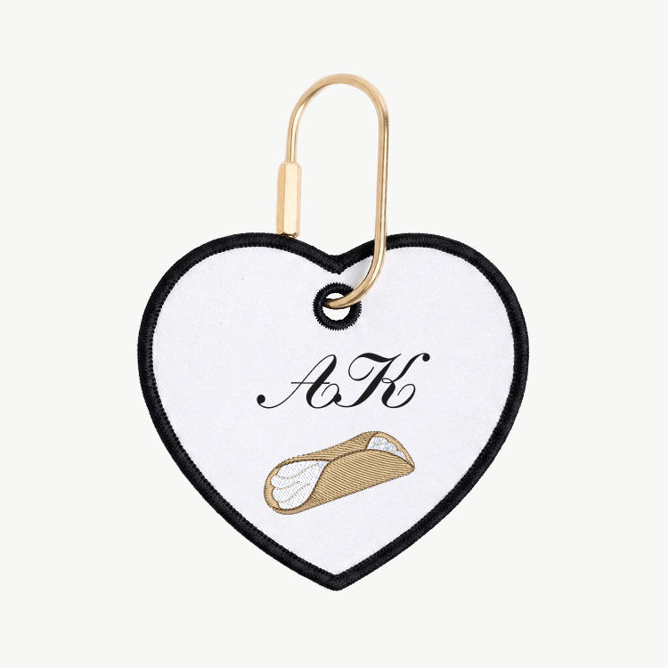 Heart-shaped keychain with initials 'A' and 'K' and a small illustration on a white background