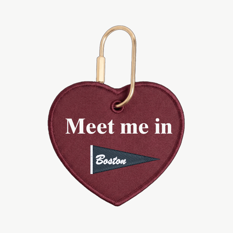 Heart-shaped keychain with 'Meet me in Boston' text on a white background