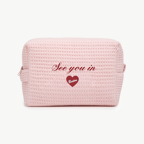 Pink textured pouch with 'See you in Boston' text and heart design on a white background