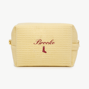 Yellow textured pouch with 'Brooke' and a sock icon on a white background