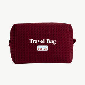 Maroon travel bag with 'Travel Bag' text and 'Boston' label on a white background