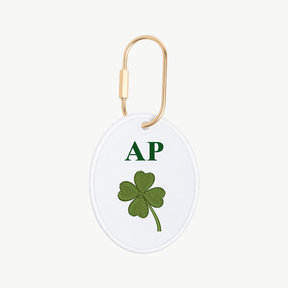 Round keychain with green four-leaf clover and 'AP' initials on a white background