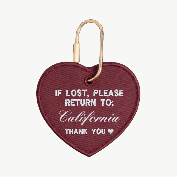 Heart-shaped keychain with 'If lost, please return to: California' text on a white background