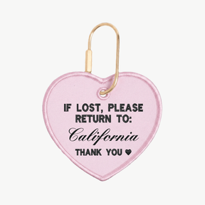 Pink heart-shaped keychain with text 'If lost, please return to: California' on a white background