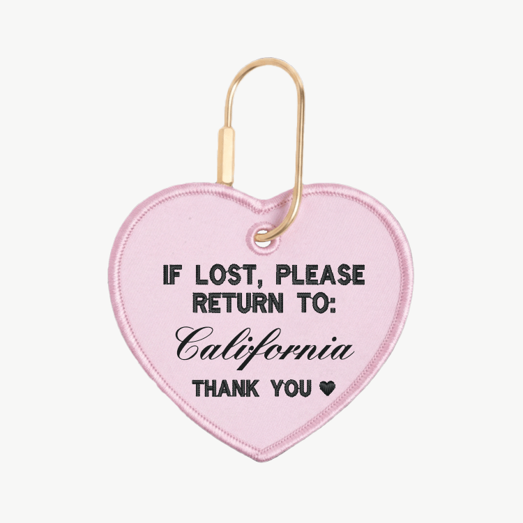 Pink heart-shaped keychain with text 'If lost, please return to: California' on a white background