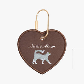 Heart-shaped keychain with 'Nala's Mom' text and cat illustration on brown background