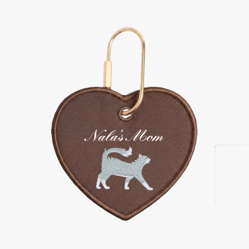 Heart-shaped keychain with 'Nala's Mom' text and cat illustration on brown background