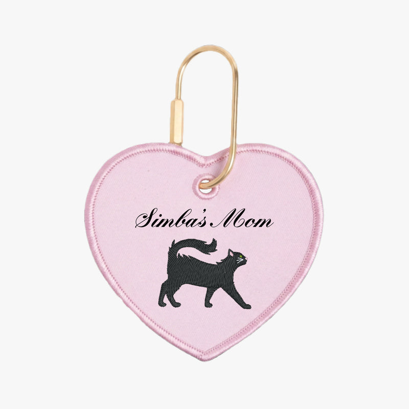Heart-shaped keychain with 'Simba's Mom' text and black cat silhouette on pink background
