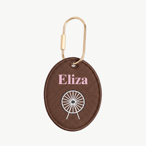 Brown keychain with 'Eliza' and a white design on a white background
