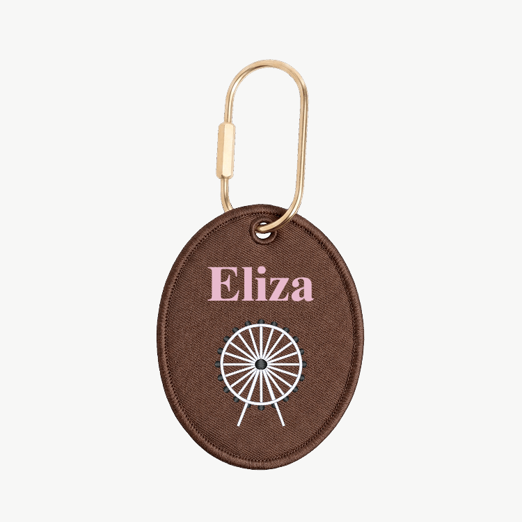 Brown keychain with 'Eliza' and a white design on a white background