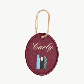Maroon keychain with 'Carly' and skyline design on a white background