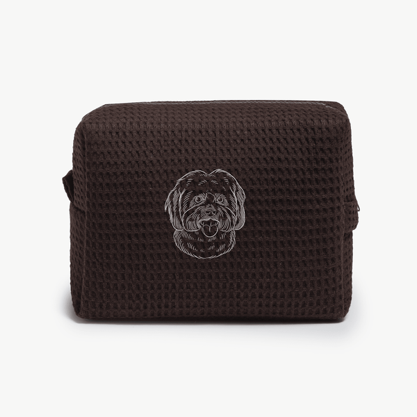 A dark brown waffle zippered pouch with a white line drawing of a dogs face on the front.