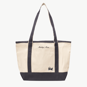 A beige canvas tote bag with long gray handles and a matching gray  base the text 'Bailey's Mom' near the top, and a small embroidered silhouette of a cat at the bottom right.
