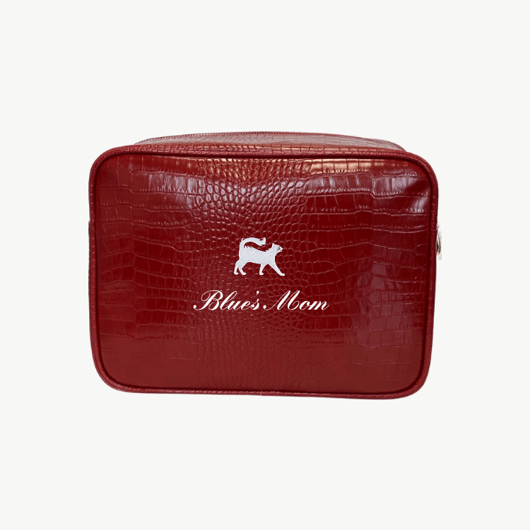 A red croc pouch featuring a gray cat emblem and the words Blue's Mom in white script on the front.