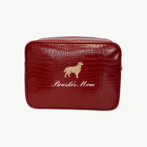 A red croc pouch featuring a large brown dog illustration and the words Bruski's Mom written in cursive on the front.