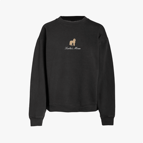 Black crewneck sweatshirt featuring a small embroidered brown dog above the words Lola's Mom in white script on the chest. The sweatshirt has long sleeves and a simple, relaxed design.