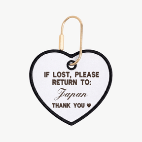 Heart-shaped tag with text 'If lost, please return to: Japan' on a white background