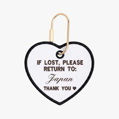 Heart-shaped tag with text 'If lost, please return to: Japan' on a white background
