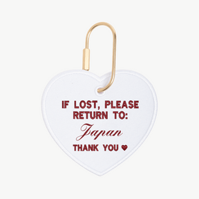 Heart-shaped tag with text 'If lost, please return to Japan' on a white background