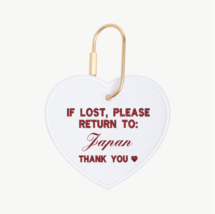Heart-shaped tag with text 'If lost, please return to Japan' on a white background