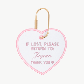 Heart-shaped tag with text 'If lost, please return to: Japan' on a white background