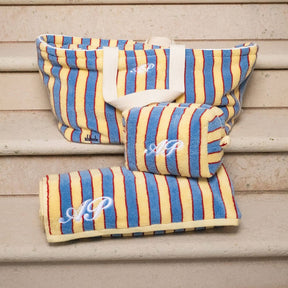 Striped fabric products with monogram on a wooden surface