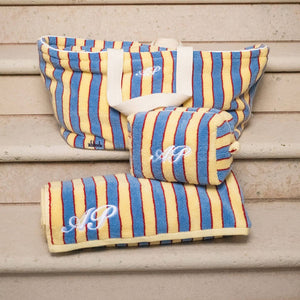 Striped fabric products with monogram on a wooden surface