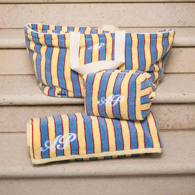 Striped fabric products with monogram on a wooden surface
