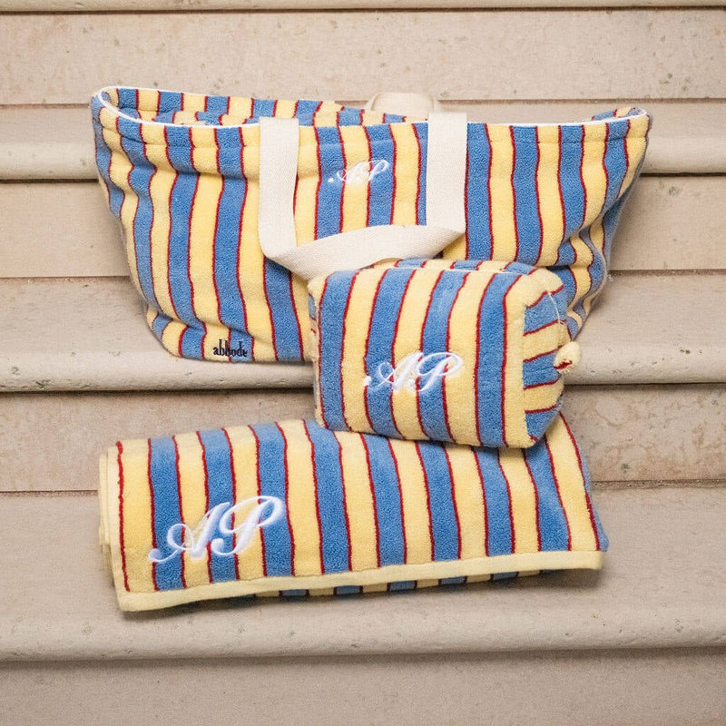Striped fabric products with monogram on a wooden surface