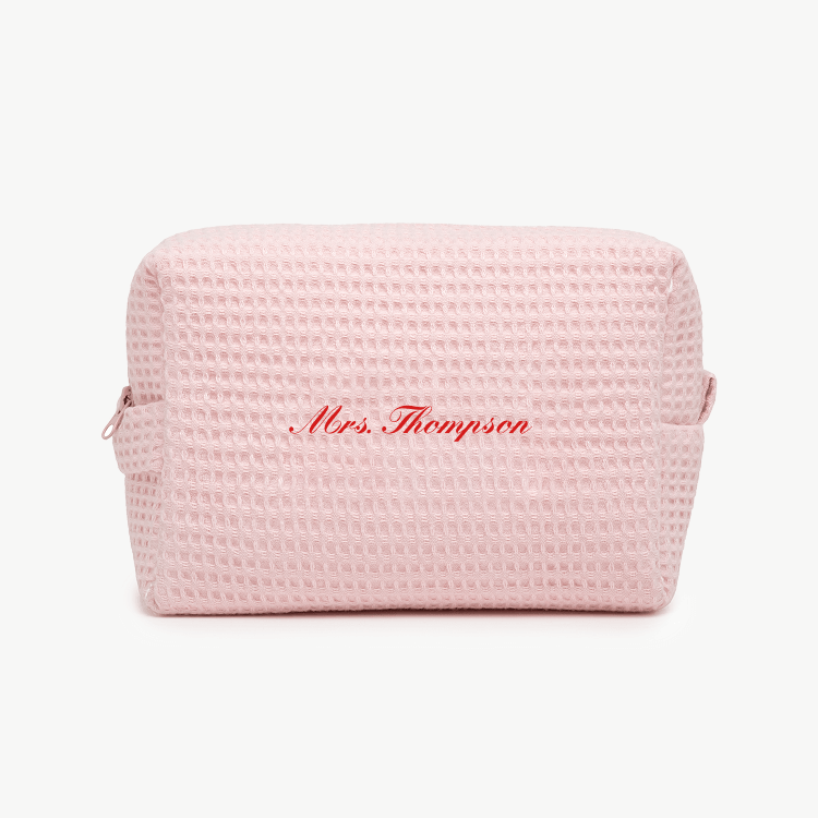 A light pink waffle pouch with the text 'Mrs. Thompson'  on the front, displayed on a plain white background.