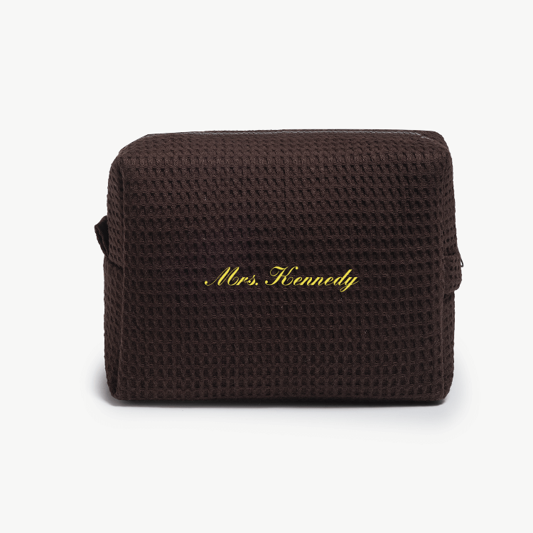A dark brown waffle pouch with the text 'Mrs. Kennedy'  on the front, displayed on a plain white background.