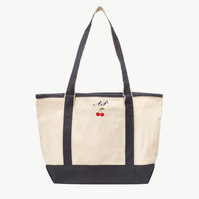 A beige canvas tote bag with long gray handles and a matching gray base, featuring 'A&P' and a cherry icon embroidered on the front, displayed on a white background.