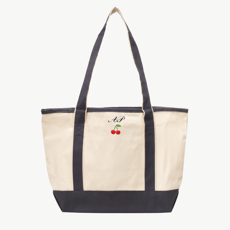 A beige canvas tote bag with long gray handles and a matching gray base, featuring 'A&P' and a cherry icon embroidered on the front, displayed on a white background.