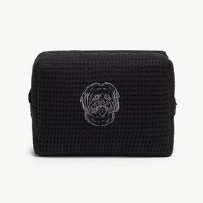 A black waffle zippered pouch with a white line drawing of a dogs face on the front.