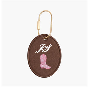 Brown keychain with pink cowboy boot and initials 'JS' on a white background