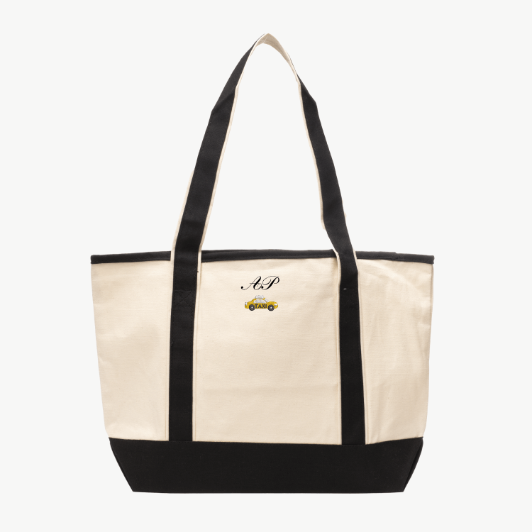 A beige canvas tote bag with long black handles and a matching black base, featuring 'AP' and a taxi icon embroidered on the front, displayed on a white background.