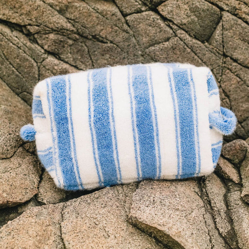 Blue and white striped poucnh on a stone surface