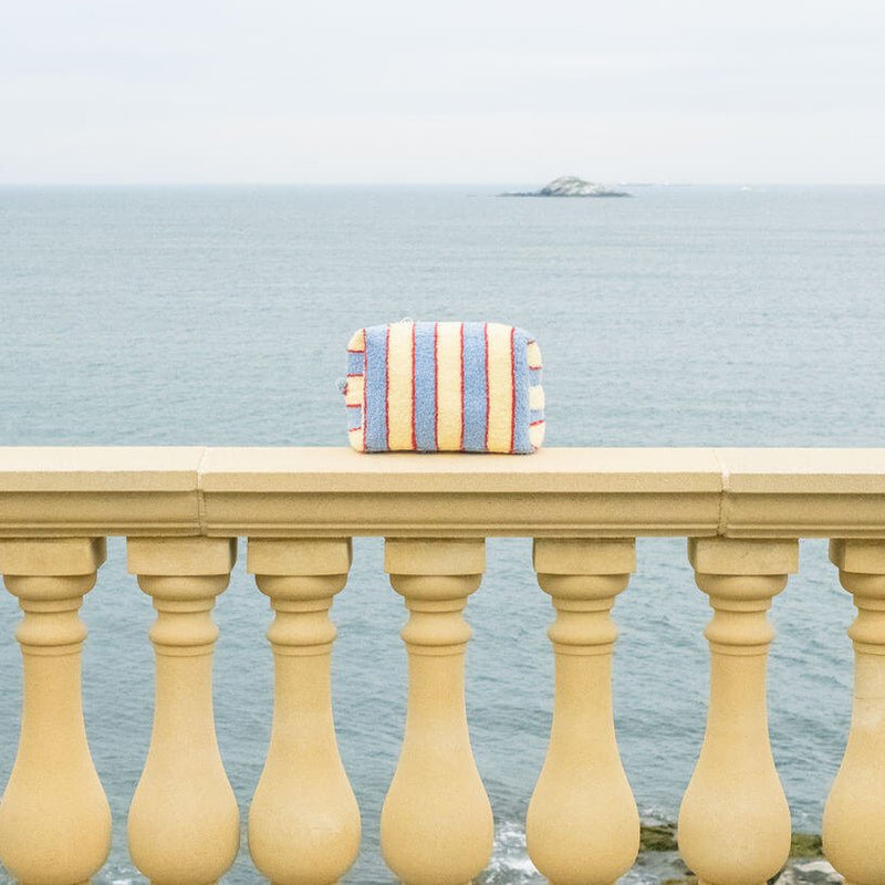 Striped bag on a railing with ocean view

