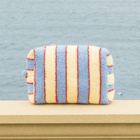 Striped pouch with red, yellow, and blue stripes on a light blue background