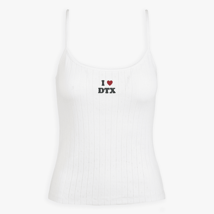 White ribbed tank top with a small embroidered design on a white background