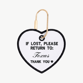 Heart-shaped tag with 'If lost, please return to: Texas' text on a white background