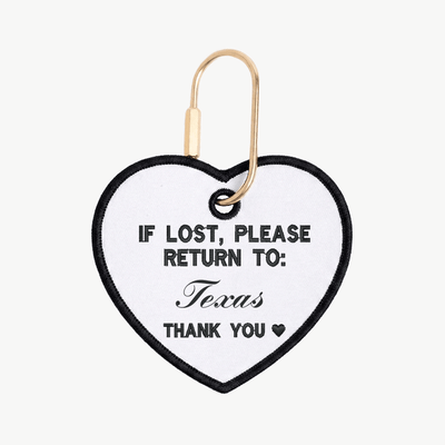 Heart-shaped tag with 'If lost, please return to: Texas' text on a white background