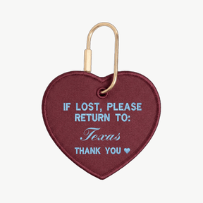 Heart-shaped keychain with text 'If lost, please return to: Texas' on a white background

