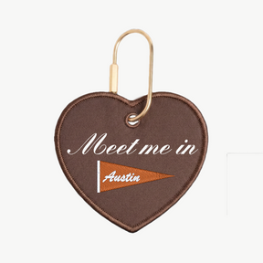 Heart-shaped keychain with 'Meet me in Austin' text on a white background