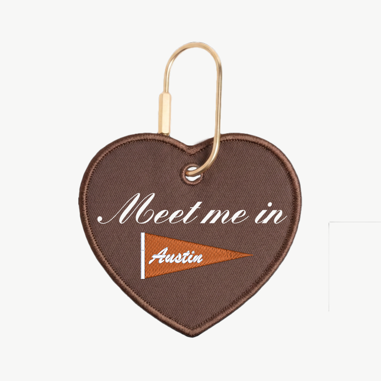 Heart-shaped keychain with 'Meet me in Austin' text on a white background